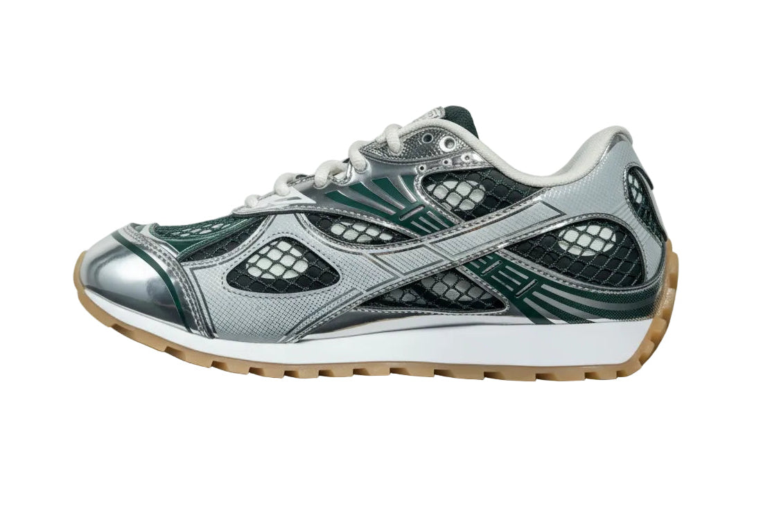 Gray and green sneaker with a white sole on a gray surface and light gray background